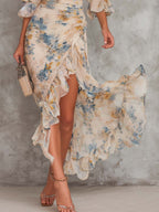 Abito Maxi Beige in Chiffon con Collo Alto, Stampa Floreale Effetto Dipinto a Olio e Orlo Asimmetrico